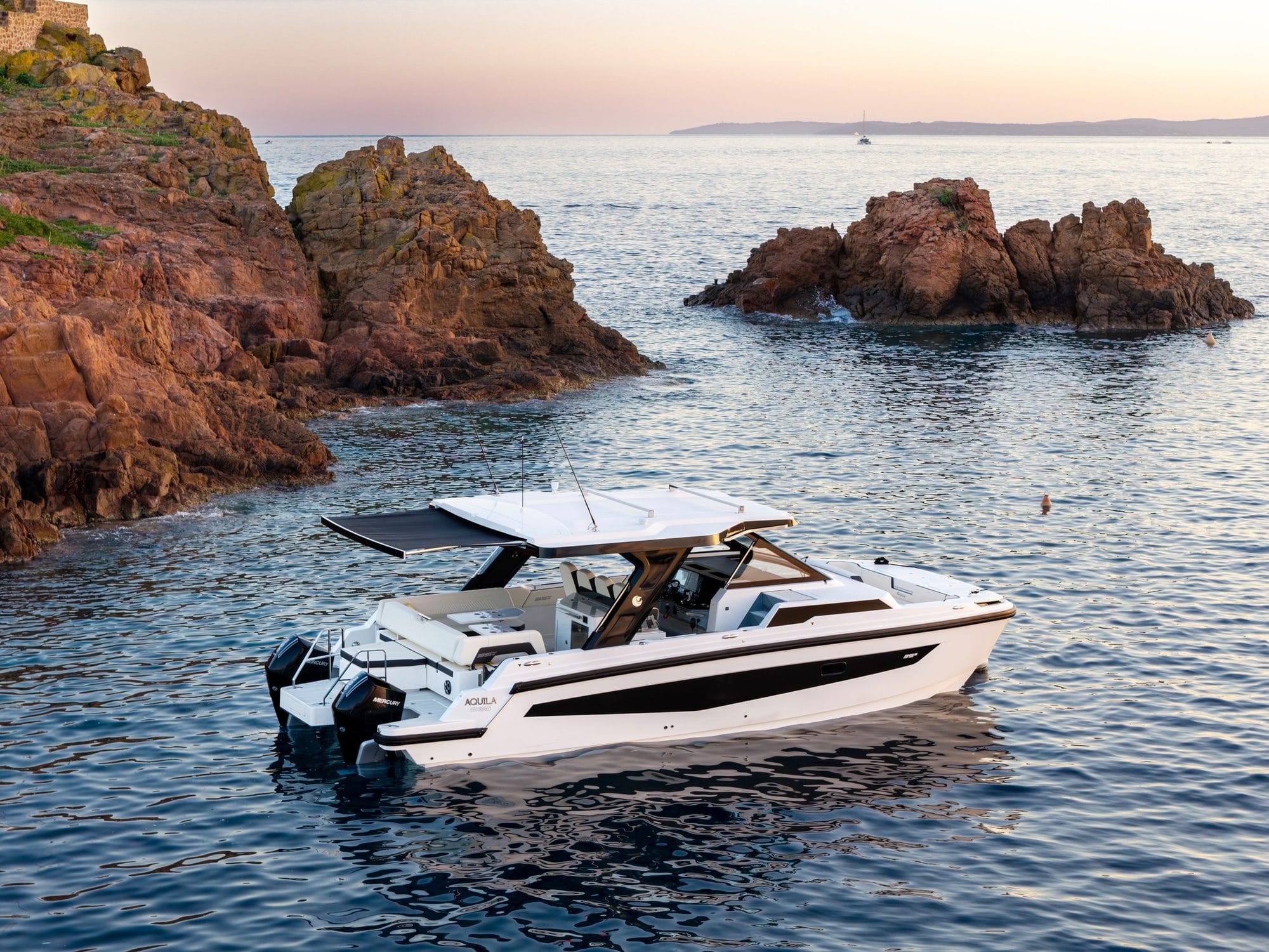 The 35 Sport at rest beside rocks in clear water