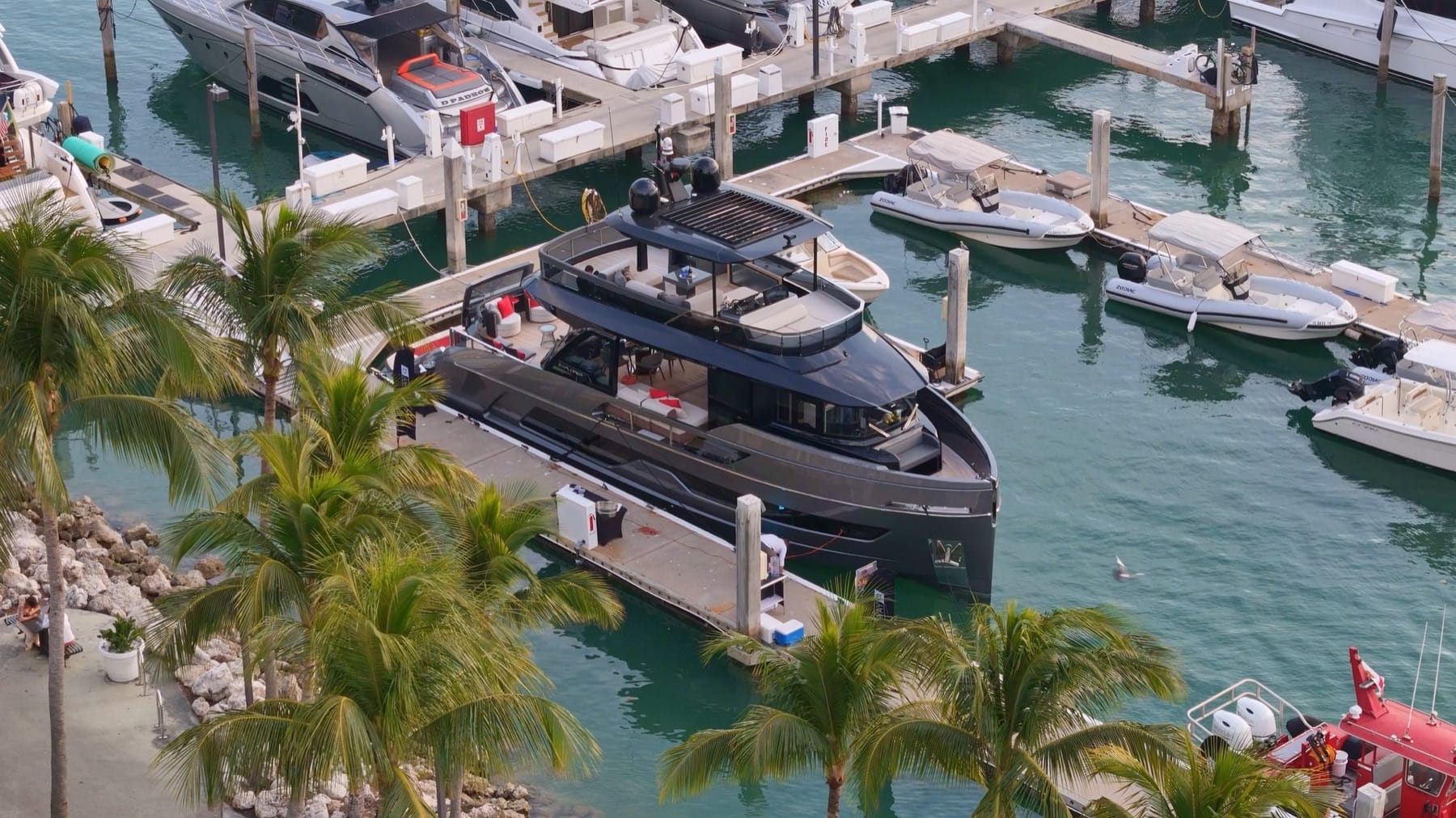 Boats in slips at a Miami marina lined with palm trees